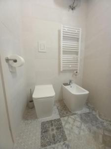 Baño blanco con aseo y lavamanos en Giura, en Lecce