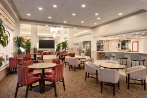 a restaurant with tables and chairs in a room at Hilton Garden Inn Fort Myers Airport/FGCU in Fort Myers