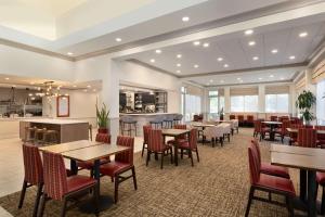 a restaurant with tables and chairs and a bar at Hilton Garden Inn Fort Myers Airport/FGCU in Fort Myers