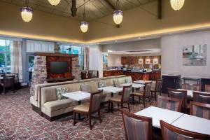 a restaurant with tables and a couch and a television at Homewood Suites by Hilton Rockville- Gaithersburg in Rockville