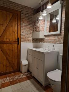 a bathroom with a sink and a toilet and a door at Dziki brzeg Jezioraka in Plajny +38 photos