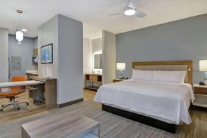 a hotel room with a bed and a desk and a desk at Homewood Suites By Hilton Chula Vista Eastlake in Chula Vista