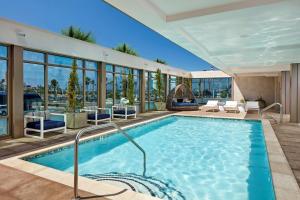 a swimming pool in a building with glass windows at Homewood Suites by Hilton San Diego Downtown/Bayside in San Diego