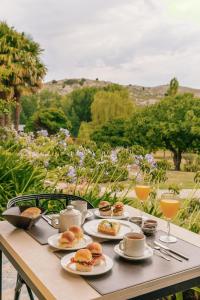 una mesa con platos de sándwiches y vasos de zumo de naranja en Hostería & Spa De La Cascada en Tandil