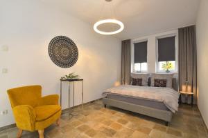 1 dormitorio con 1 cama y 1 silla amarilla en Balthasar en Rudolstadt