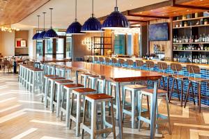 un bar con mesas de madera y taburetes en un restaurante en Hilton Garden Inn San Diego Downtown/Bayside, CA en San Diego