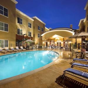 a pool at a hotel with chairs and a hotel at Homewood Suites by Hilton Carlsbad-North San Diego County in Carlsbad