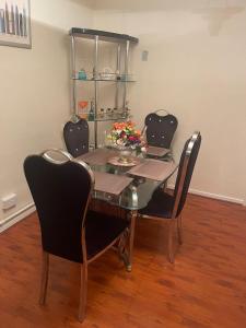 mesa de comedor con 4 sillas y mesa de cristal en BT luxury Apartment, en Londres
