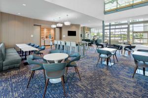 a lobby with tables and chairs and a cafeteria at Hampton Inn & Suites San Diego Airport Liberty Station in San Diego
