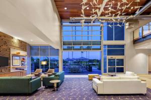 an office lobby with couches and chairs and windows at Hampton Inn & Suites San Diego Airport Liberty Station in San Diego