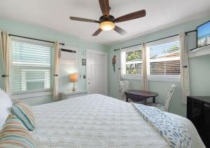 una camera con letto e ventilatore a soffitto di The Grand Guesthouse a Key West