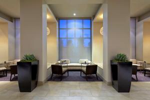 a waiting room with tables and chairs and a large window at Hilton San Diego Mission Valley in San Diego