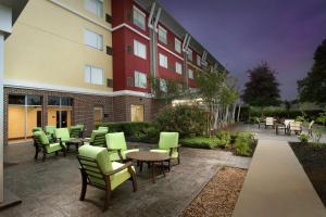 um grupo de cadeiras e mesas fora de um edifício em Hilton Garden Inn San Antonio Airport South em San Antonio