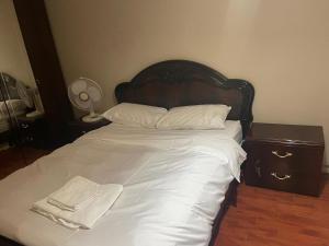 Una cama con sábanas blancas y toallas blancas. en BT luxury Apartment, en Londres