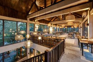 un restaurante interior con mesas, sillas y ventanas en Coco Island Villa & Hotel Ninh Bình en Ninh Binh