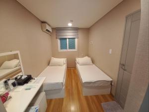 a small room with two beds and a sink at Ohmy Inn Dongdaemun in Seoul