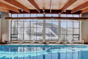 a large swimming pool with chairs and a large window at Evergreen Condominiums by Keystone Resort in Keystone