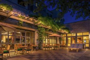 an outdoor patio with tables and chairs at night at Hilton San Antonio Hill Country in San Antonio