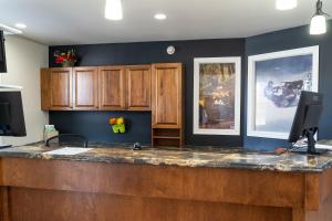 a kitchen with a wooden counter top and blue walls at Hôtel Marineau Centre in La Tuque