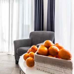 un bol d'oranges sur une table à côté d'une chaise dans l'établissement Made to Measure Business, à Milan