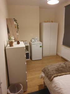 una camera con letto e una cucina con frigorifero di Cozy bedroom C a Londra