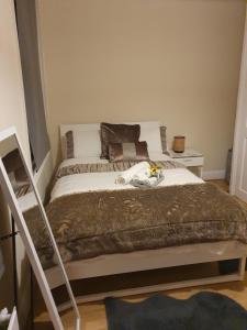Cozy bedroom C في لندن: غرفة نوم مع سرير وبطانية بنية اللون