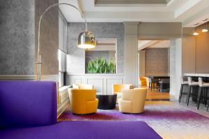 a lobby with yellow and purple chairs and a table at DoubleTree by Hilton Historic Savannah in Savannah