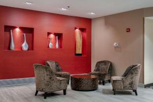 a waiting room with chairs and a table and vases at DoubleTree by Hilton Hotel Savannah Airport in Savannah