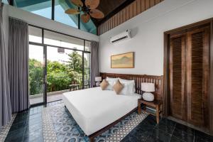 a bedroom with a white bed and a large window at Coco Island Villa & Hotel Ninh Bình in Ninh Binh