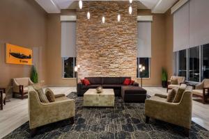 a living room with a couch and chairs and a brick wall at DoubleTree by Hilton Hotel Savannah Airport in Savannah