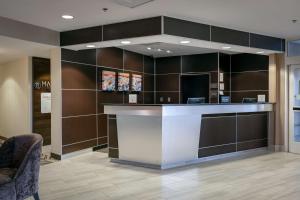 a lobby with a counter and chairs in a room at DoubleTree by Hilton Hotel Savannah Airport in Savannah