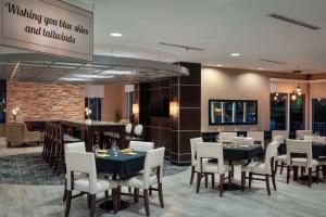 a restaurant with tables and chairs and a bar at DoubleTree by Hilton Hotel Savannah Airport in Savannah