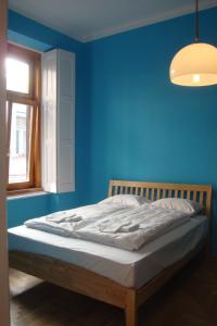 1 dormitorio azul con 1 cama con pared azul en Market Square Apartment II., en Budapest