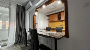 a dining room with a table and chairs and a mirror at MarioApartCentralView in Timişoara