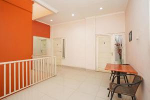un couloir avec des murs orange et blancs et une table en bois dans l'établissement Semampir Residence By Occupied, à Surabaya