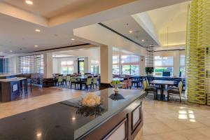 a dining room with tables and chairs in a building at Hilton Garden Inn South Bend in South Bend