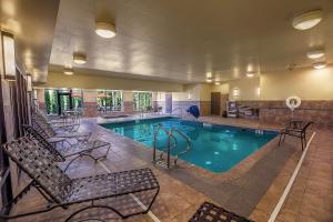 a large swimming pool with chairs and a swimming pool at Hilton Garden Inn South Bend in South Bend