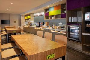 a fast food restaurant with wooden tables and chairs at Home2 Suites By Hilton Lewes Rehoboth Beach in Lewes