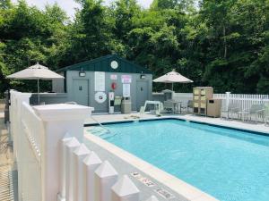 a swimming pool with a white fence and a building at Hyatt Place Mystic in Mystic