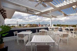 un patio avec des tables et des chaises blanches sur le toit dans l'établissement Fenwick Shores, Tapestry Collection by Hilton, à Fenwick Island