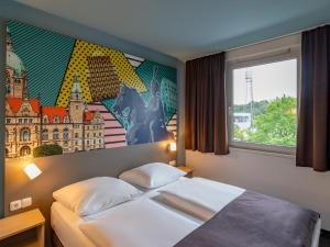 ein Hotelzimmer mit einem Bett und einem Fenster in der Unterkunft B&B Hotel Hannover-Lahe in Hannover