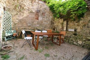 サン・タントナンにあるLa Rêverieの石壁の前に木製のテーブルと椅子