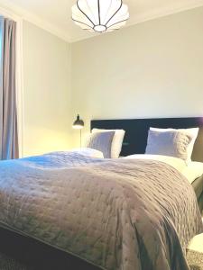 a bedroom with a large bed and a chandelier at Amazing Flat in Urban Neighborhood in Copenhagen