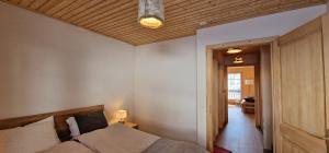 ein Schlafzimmer mit einem Bett und einer Holzdecke in der Unterkunft Narcisse 14 in Champoussin