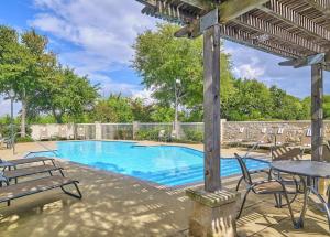 a swimming pool with chairs and a table and a pergola at Hampton Inn and Suites Schertz in Schertz