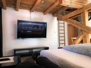 a person laying on a bed in a room with a tv at Bikers Paradise Apartment in Oberlängenfeld