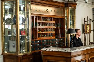 Ein Mann, der an einer Bar in einer Bibliothek sitzt. in der Unterkunft Hôtel Eldorado Paris in Paris