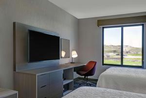 a hotel room with a desk with a flat screen tv at Hampton Inn Patterson, Ca in Patterson