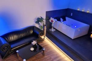un soggiorno con divano in pelle nera e vasca da bagno di Privat-Spa mit Whirlpool und Sauna in Sursee a Sursee
