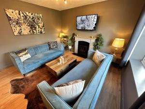 uma sala de estar com sofás azuis e uma lareira em No50 - 2-bed Boutique Apartment - Hosted by Hutch Lifestyle em Leamington Spa
